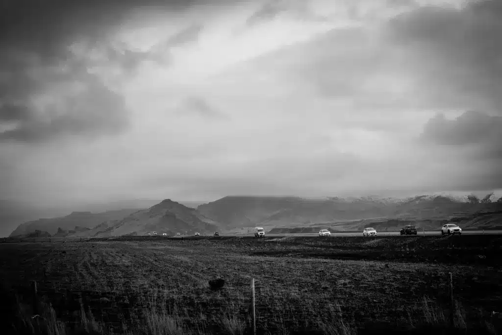 Walking to the Solheimasandur plane wreck with the South Coast traffic behind us in Iceland.