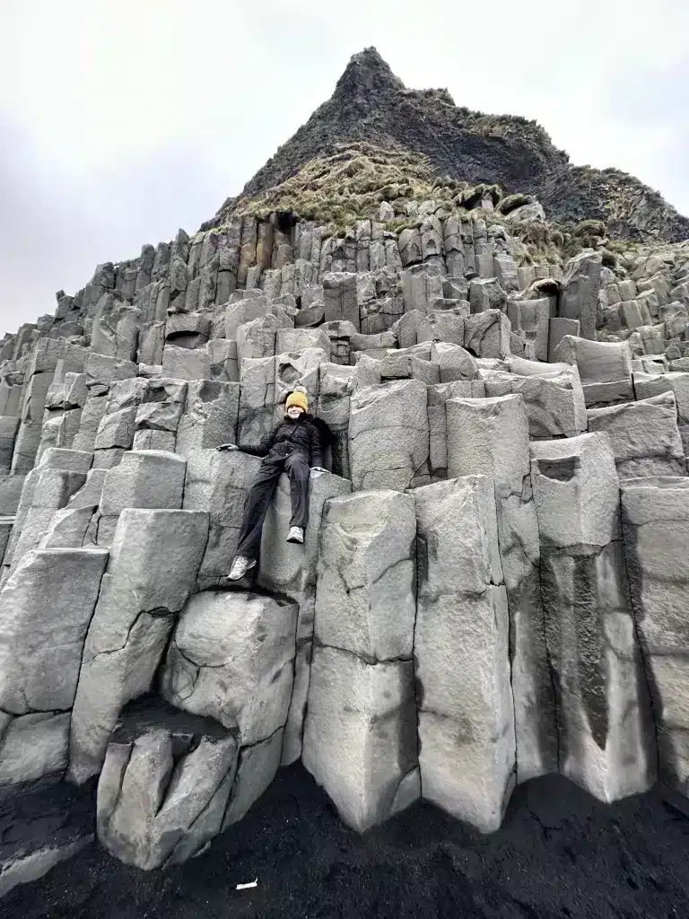 Sitting on the basalt columns of Reynisfjara Black Sand Beach.