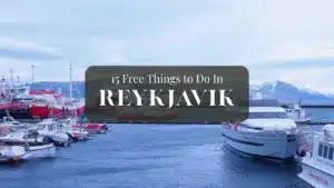 Boats docked in a harbor with snow-capped mountains in the background and text overlay "15 Free Things to Do In REYKJAVIK".